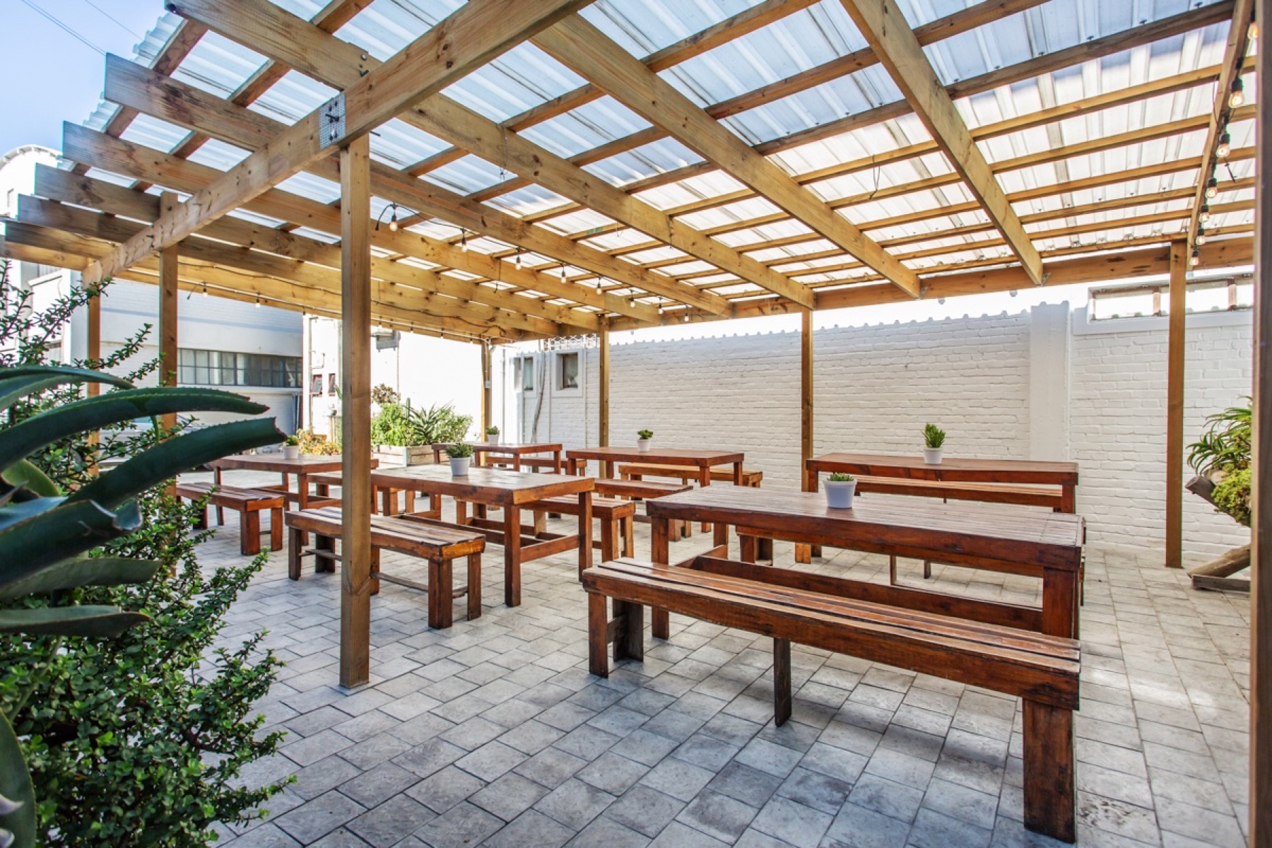 The covered outdoor courtyard at Colorbox Studios with timber tables and string lights