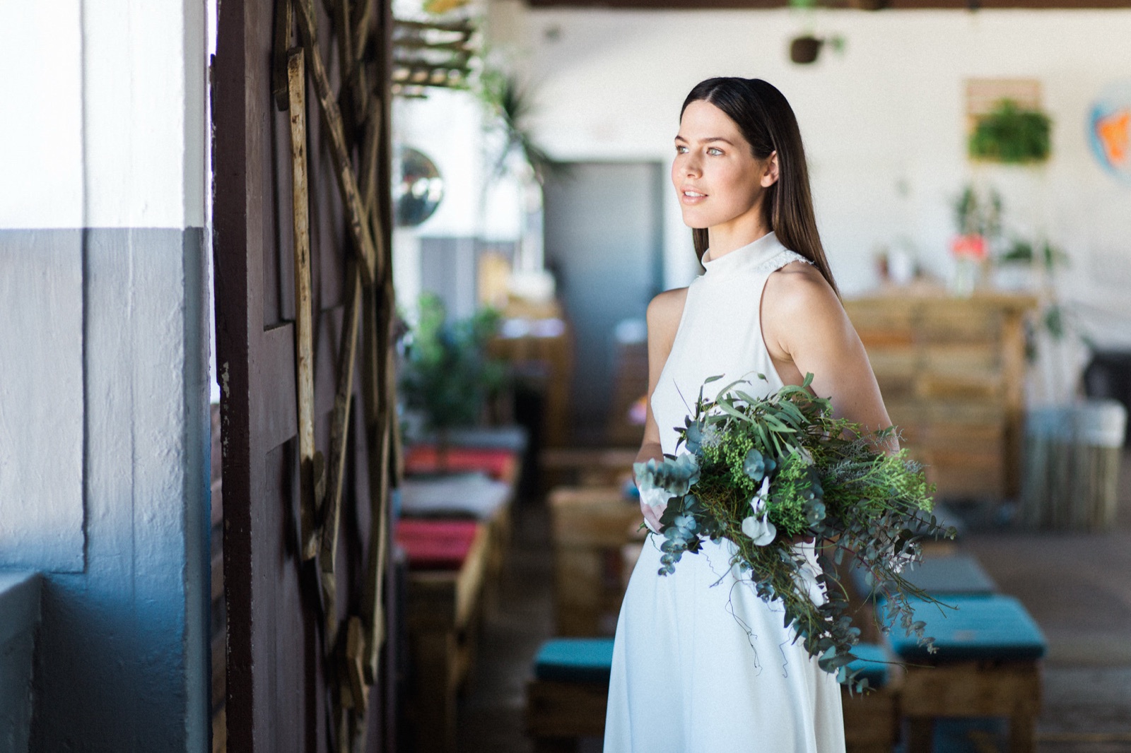 A bride with a eucalyptus bouquet inside Colorbox Studios